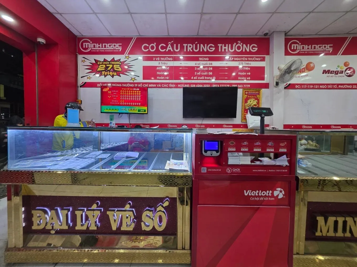 Quầy vé số và máy bán vé Vietlott tại đại lý Minh Ngọc, phía sau là bảng cơ cấu trúng thưởng
